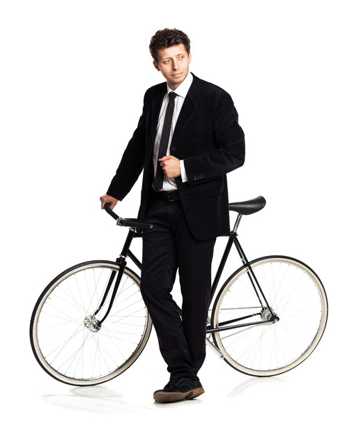 Attractive man in a classic suit with a bicycle on a white - Фото, зображення
