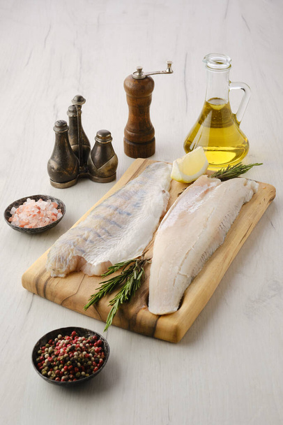 Raw zander fillet on wooden cutting board with spices - Photo, image