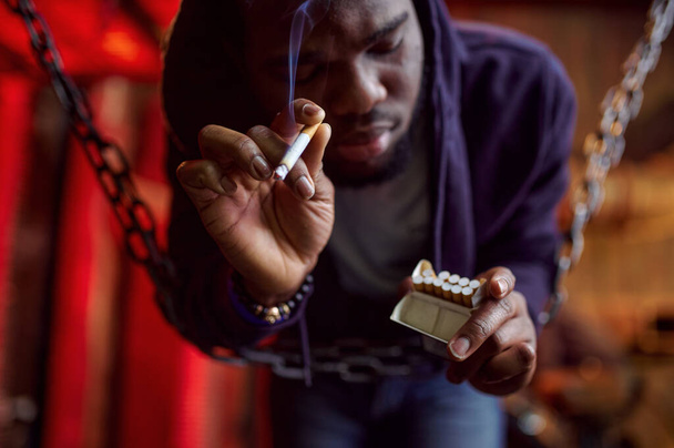 麻薬中毒の男がタバコを吸って撤退中の麻薬中毒だ。麻薬中毒の問題ジャンキーの人々の永遠のうつ病 - 写真・画像
