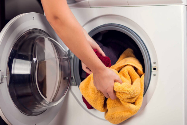 Carregando roupas na máquina de lavar roupa. Trabalho doméstico, conceito de lavanderia - Foto, Imagem