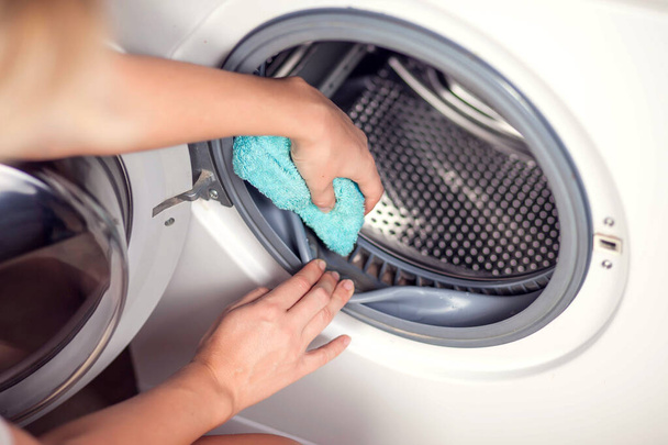 Piszkos penészes mosógép tömítő gumi és dob közelről. Penész, kosz, mészkő a mosógépben. Háztartási készülékek időszakos karbantartása. - Fotó, kép