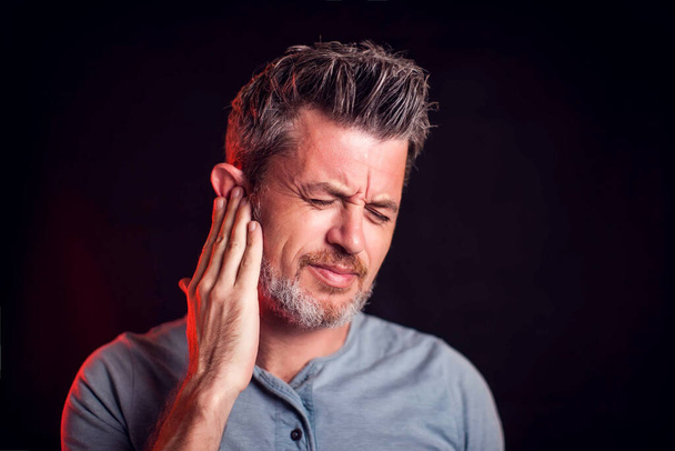 Adam kulak ağrısını hisseder. Halk, sağlık ve tıp konsepti - Fotoğraf, Görsel
