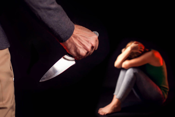 Man met mes wil een vrouw vermoorden. Mensen, gezinsgeweld, misdaadconcept - Foto, afbeelding