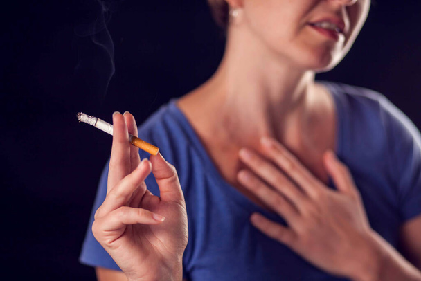 女性はタバコを吸って、黒い背景に肺や心臓の痛みを持っています。タバコ中毒と健康問題の概念 - 写真・画像