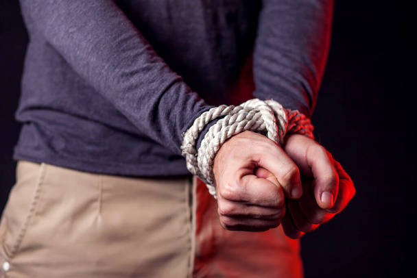 Megkötözött kezű férfi. Emberi erőszak és büntetőjogi koncepció - Fotó, kép