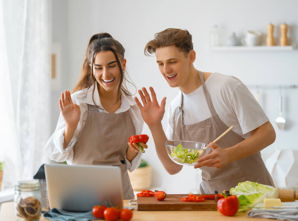 Healthy food at home. Happy loving couple is preparing the proper meal in the kitchen. - Foto, afbeelding