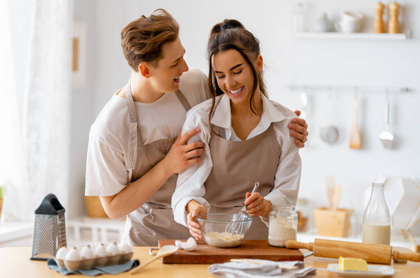 Happy loving couple is preparing the pastry in the kitchen. - Valokuva, kuva