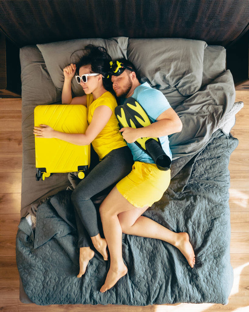 pareja en la cama con bolsa de viaje listo para las vacaciones de verano mar vista superior - Foto, imagen