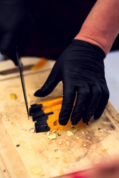 Az eladó sajtot készít a sajt fesztiválon. Bio- és mezőgazdasági élelmiszer-koncepció - Fotó, kép