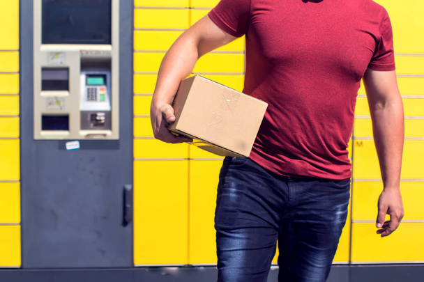 Man received a parcel using automated self-service post terminal machine or locker  - Photo, Image