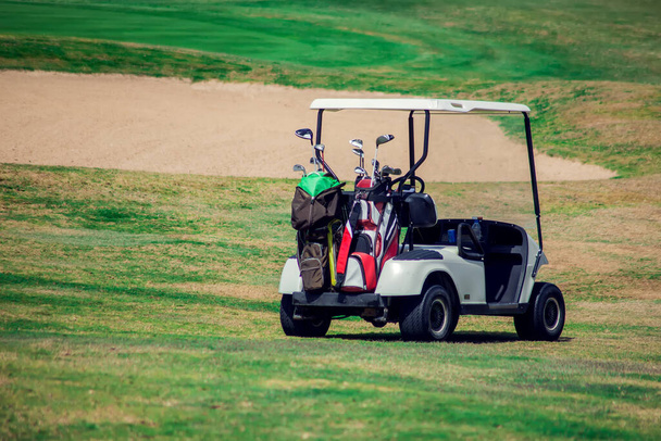 芝生のスポーツフィールド上のゴルフカート。スポーツとライフスタイルのコンセプト - 写真・画像