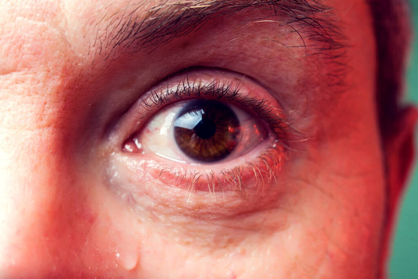 Göz yaşı döken bir adamın yakın çekim kahverengi gözü. İnsanlar, duygu konsepti - Fotoğraf, Görsel