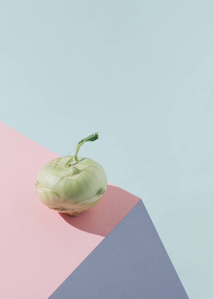 Cena vegetal verde feita de kohlrabi iluminado pelo sol no fundo azul pastel rosa, violeta e pastel. Ideia alimentar orgânica, crua e saudável. Arranjo mínimo de primavera e verão com espaço de cópia. - Foto, Imagem
