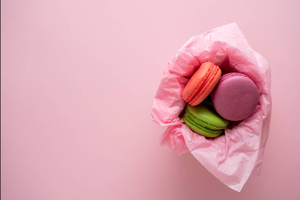 biscuits aux amandes sont dans un panier sur un fond rose. délicieux et doux dessert. Vue du dessus, plan, espace de copie - Photo, image