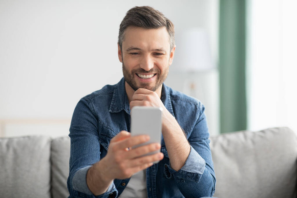 Happy middle-aged man enjoying video chat with lover - Foto, Bild