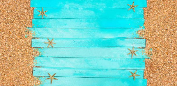 Ναυτική σημαία. Τυρκουάζ οριζόντιες ξύλινες σανίδες με βοτσαλωτή άμμο και αστερία. Ταξίδια και τουρισμός. Θερινό φόντο. Αντιγραφή χώρου - Φωτογραφία, εικόνα