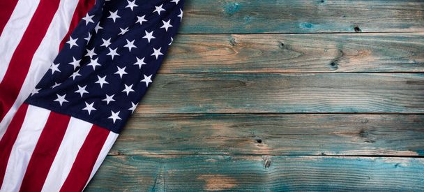 Mutlu bir anma töreni ya da Bağımsızlık Günü konsepti için solmuş mavi tahta levhaların üzerinde Amerikan bayrağı sallıyor.  - Fotoğraf, Görsel