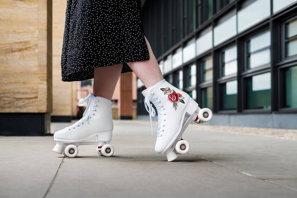 Side view of young woman on black skirt roller skating. Close up - Photo, Image