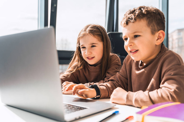 Хлопчик і дівчинка в ноутбуці. Дистанційне навчання
 - Фото, зображення