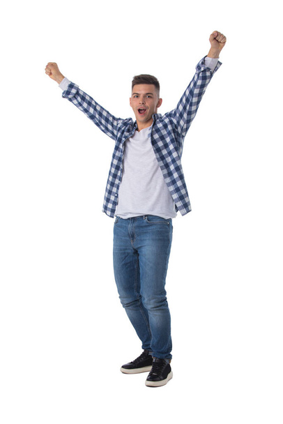 Full length portrait of a young man with arms raised isolated on a white background - 写真・画像