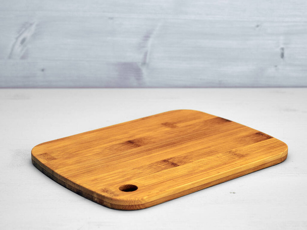 Tagliere bordo di legno su superficie di legno verniciato grigio chiaro e sfondo grigio. - Foto, immagini
