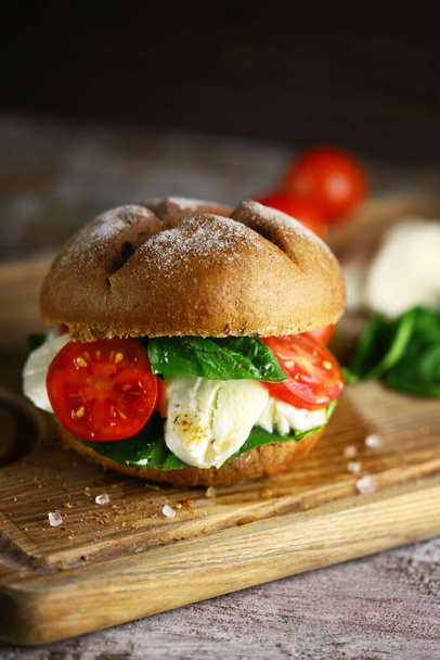 Mozzarella sandwich. A healthy sandwich with mozzarella, tomato and spinach. Caprese sandwich. A healthy snack. - Фото, изображение
