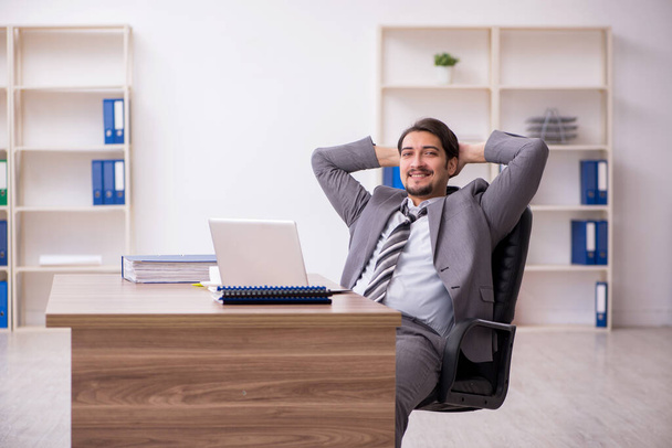 Mladý atraktivní muž zaměstnanec sedí na pracovišti - Fotografie, Obrázek