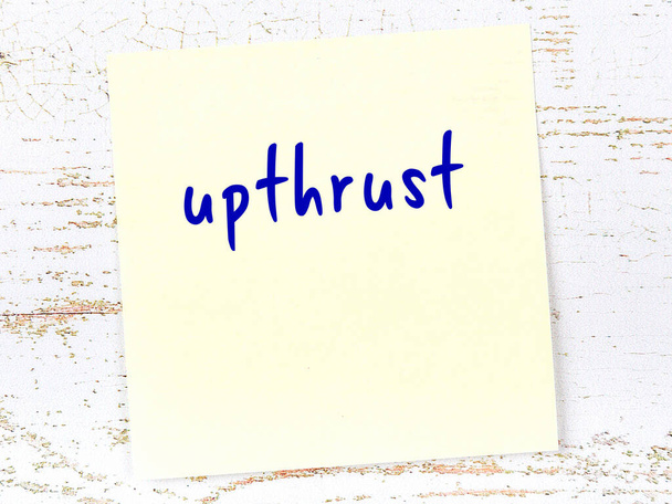 Concept of reminder about upthrust. Yellow sticky sheet of paper on wooden wall with inscription - Photo, Image