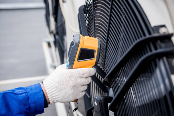Technician uses a thermal imaging infrared thermometer to check the condensing unit heat exchanger. - Zdjęcie, obraz