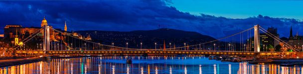 ブダペストの夜、ドナウ川のエルゼベト橋、水の夜の光の反射、パノラマショット - 写真・画像