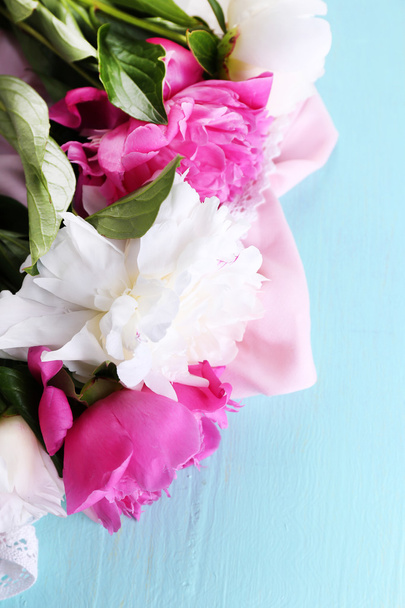 Beautiful pink and white peonies on color wooden background - Fotó, kép