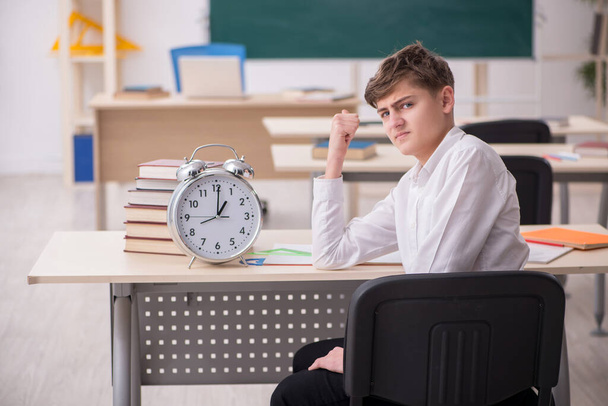 Alumno masculino en concepto de gestión del tiempo - Foto, imagen