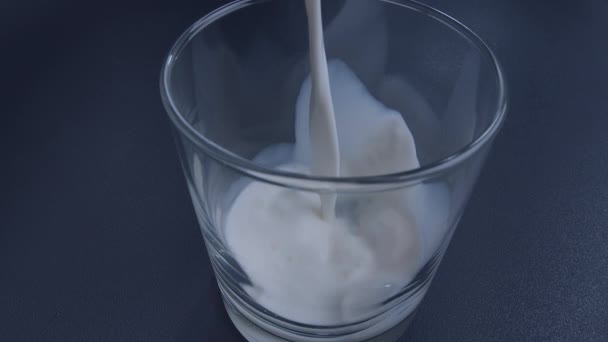 Il latte fresco è versato in un bicchiere, primo piano - Filmati, video