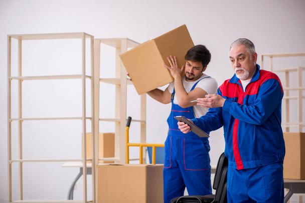 Dos hombres mudantes profesionales haciendo la reubicación del hogar - Foto, Imagen