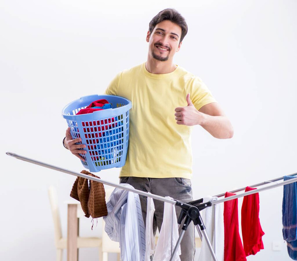 Handsome man husband doing laundering at home - Foto, imagen