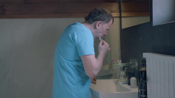 Seitenansicht eines jungen Mannes, der in den Spiegel schaut, Zähne putzt, Kameratracking - Filmmaterial, Video