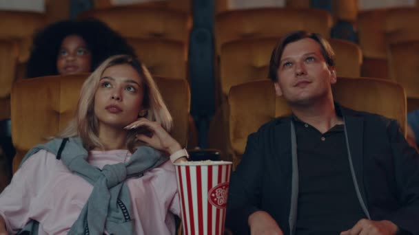 Atractiva joven pareja caucásica alegre riendo mientras ve el cine en el cine. Concepto de entretenimiento de estilo de vida. - Imágenes, Vídeo