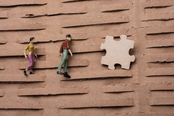 puzzle kawałek i malutka figurka mężczyzny i kobiety miniaturowy model w perspektywie - Zdjęcie, obraz