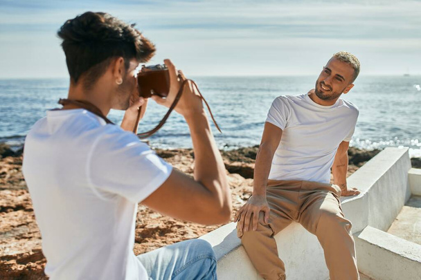 Denizin önünde erkek arkadaşının fotoğraflarını çeken bir adam.. - Fotoğraf, Görsel