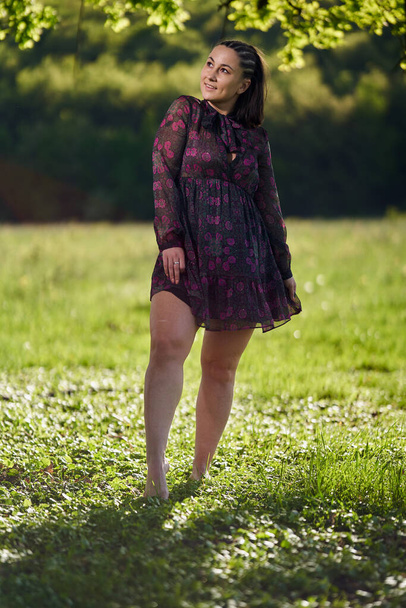 Beautiful size plus female model in a field of wild flowers by the forest - Foto, afbeelding