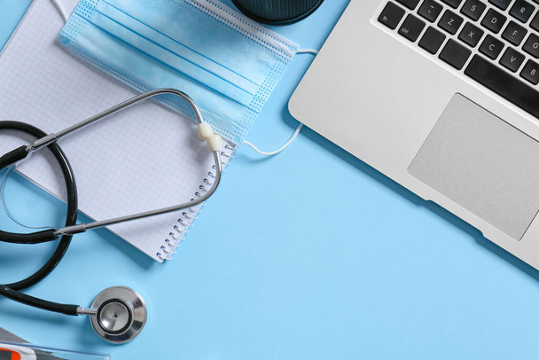 Composition with modern stethoscope and laptop on color background - Foto, imagen