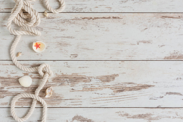 Sea background with marine rope and seashells on white wooden deck top view. Summertime sea background. - Foto, Bild