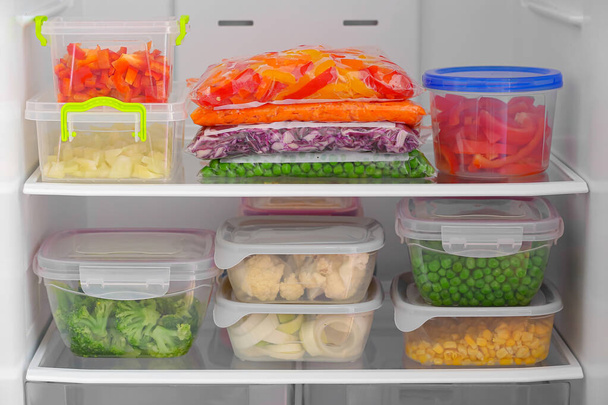 Behälter und Plastiktüten mit Gemüse im Kühlschrank - Foto, Bild