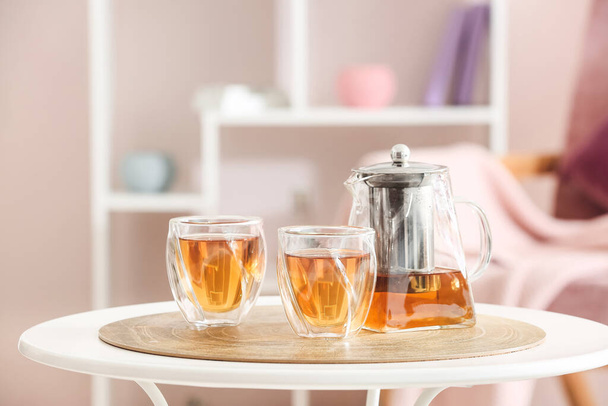 Czajnik i szklanki z gorącą herbatą na stole w kuchni - Zdjęcie, obraz