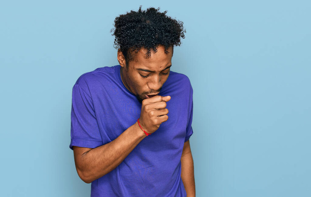 Young african american man with beard wearing casual purple t shirt feeling unwell and coughing as symptom for cold or bronchitis. health care concept.  - 写真・画像