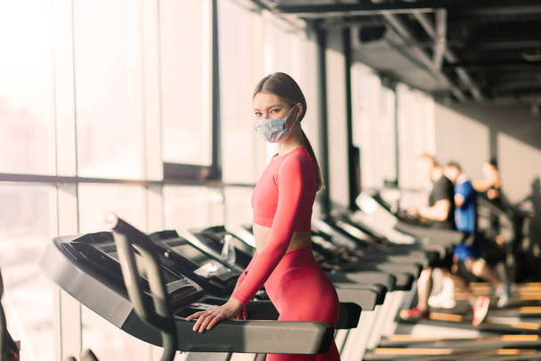 Γυναίκα φορώντας μάσκα προσώπου προπόνηση άσκηση στο γυμναστήριο κατά τη διάρκεια του ιού της κορώνας πανδερμική, covid - Φωτογραφία, εικόνα