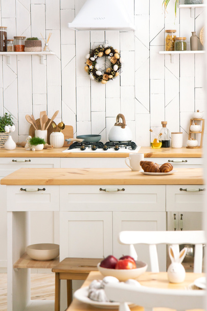 Interior de la cocina blanca con una planta en una encimera de madera. Nuevo interior de cocina moderna. Minimalismo - Foto, Imagen