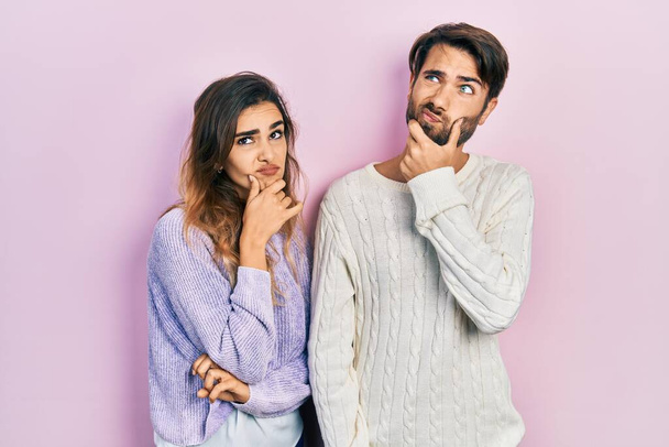 Young hispanic couple wearing casual clothes thinking worried about a question, concerned and nervous with hand on chin  - Foto, imagen