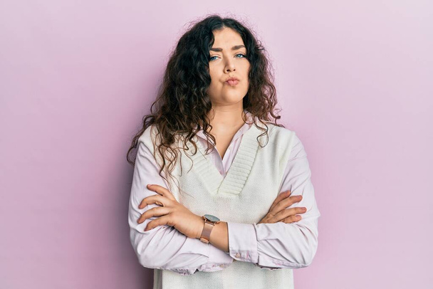 Young brunette woman with curly hair wearing casual clothes skeptic and nervous, disapproving expression on face with crossed arms. negative person.  - Photo, Image