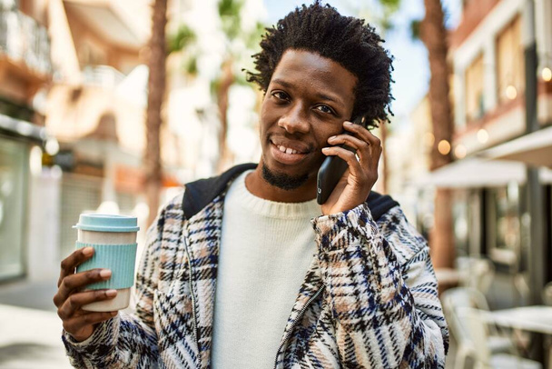 bello nero uomo con afro capelli avendo un conversazione parlando al telefono - Foto, immagini